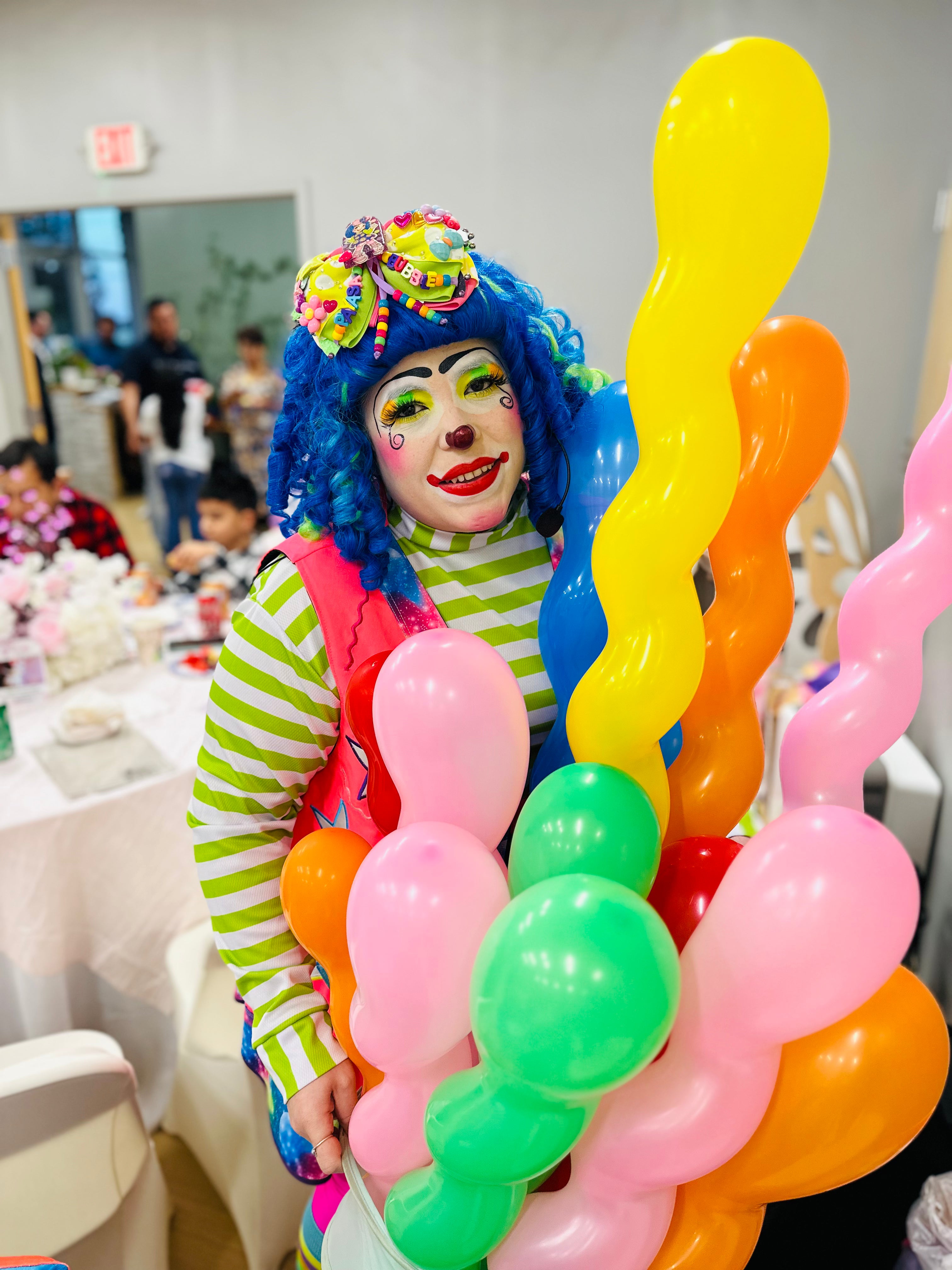 Colorful clown entertaining kids at a birthday party with balloons and fun decorations